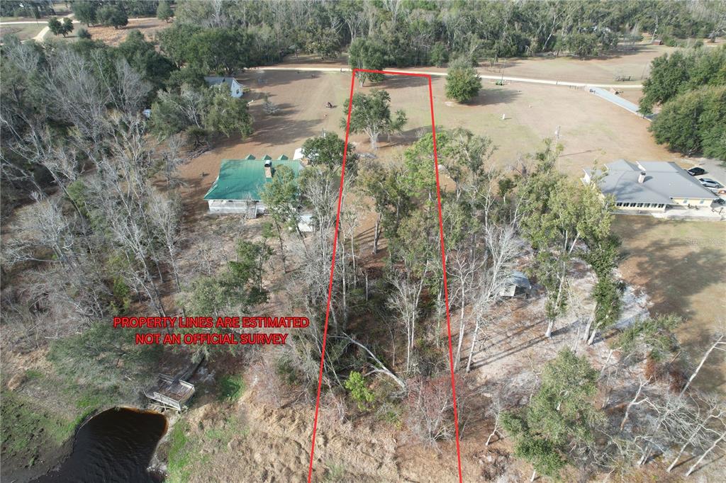 An aerial view shows a house with a green roof and a marked property boundary — 00 NW BUR OAK PLACE, JENNINGS, FL
