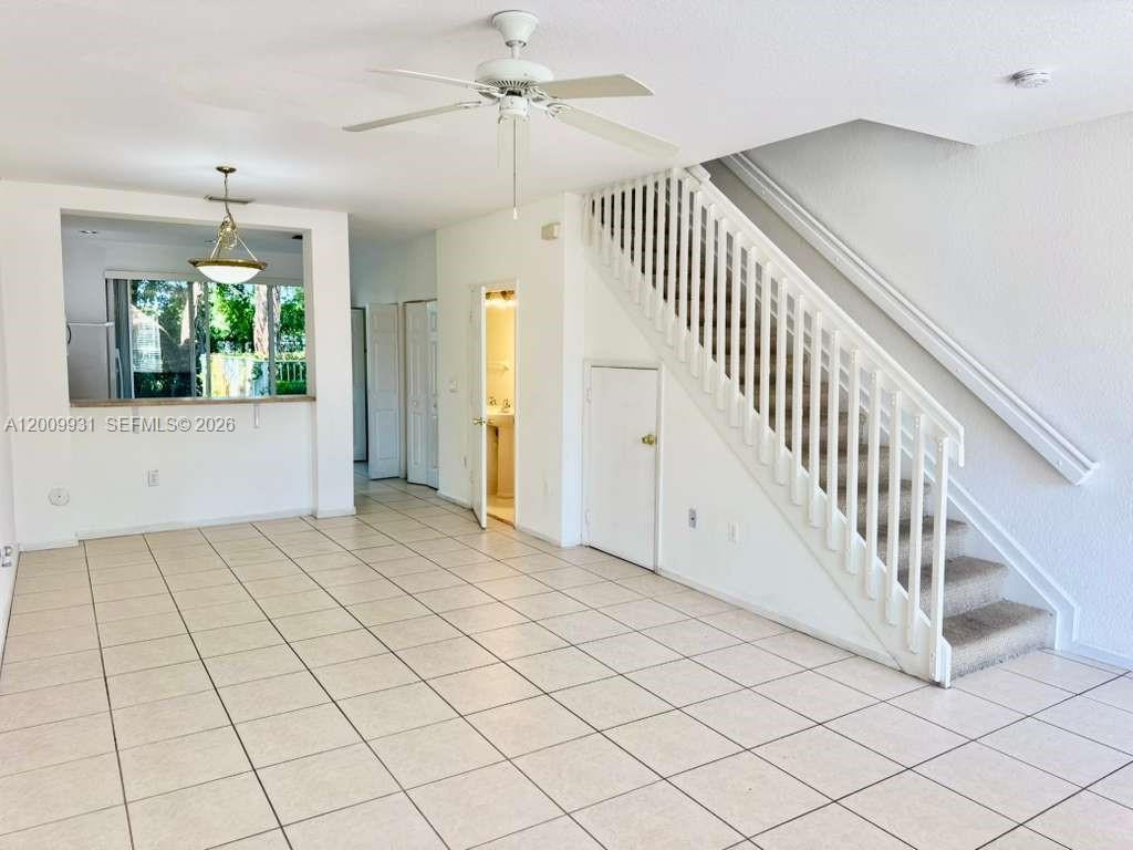 An interior view shows a tiled living area with a staircase and a kitchen pass-through — 669 NW 42nd Ave, Plantation FL 33317, PLANTATION, FL