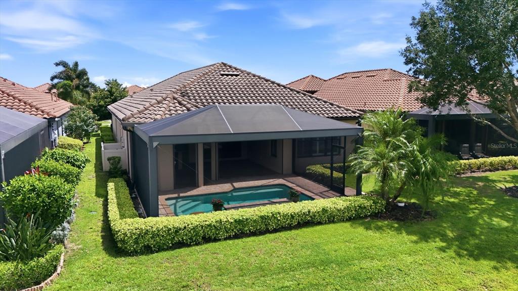 An aerial view of a house with a screened-in pool and a manicured hedge — 12749 FONTANA LOOP, BRADENTON, FL