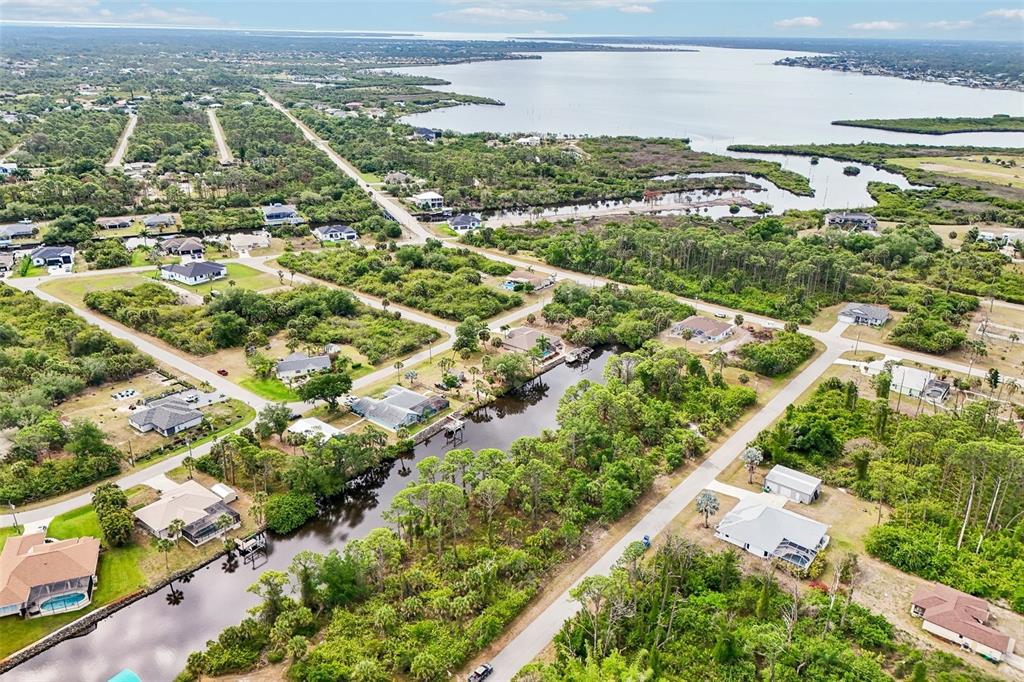 An aerial view shows houses situated along a canal leading toward a large body of water — 1168 ANAHEIM STREET, PORT CHARLOTTE, FL
