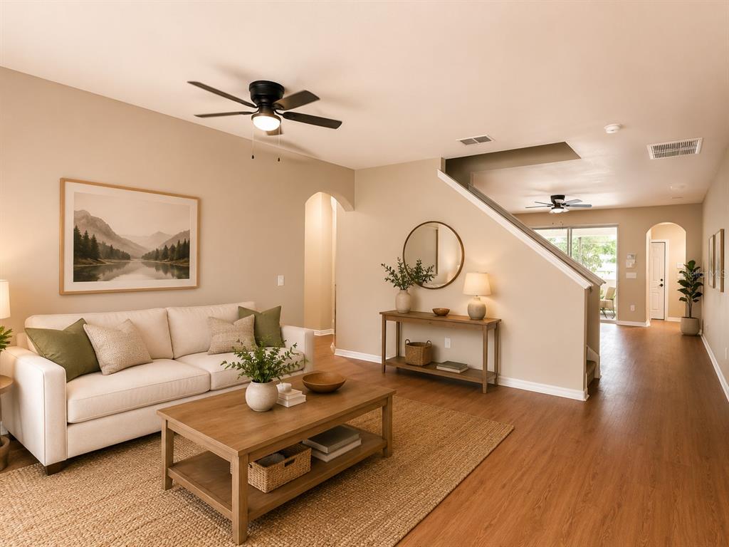 A living room features a white sofa, wooden coffee table, and stairs leading to a hallway — 1124 FENNEL GREEN DR, SEFFNER, FL