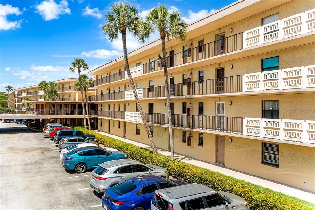 A multi-story apartment building with exterior walkways and a parking lot in the foreground — 9355 SW 8th Street # 109, Boca Raton FL 33428, BOCA RATON, FL