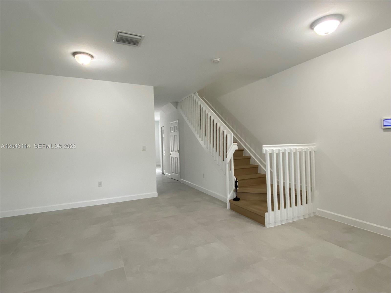 A room with light tile flooring features a staircase with white railings and wood steps — 3538 W 88th Terrace # 3538, Hialeah Gardens FL 33018, HIALEAH GARDENS, FL