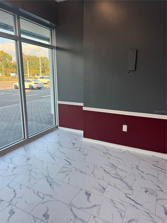 An interior room features white marble-look tile flooring, two-tone walls, and large floor-to-ceiling windows — 5113 STATE ROAD 674 SUITE 108, WIMAUMA, FL