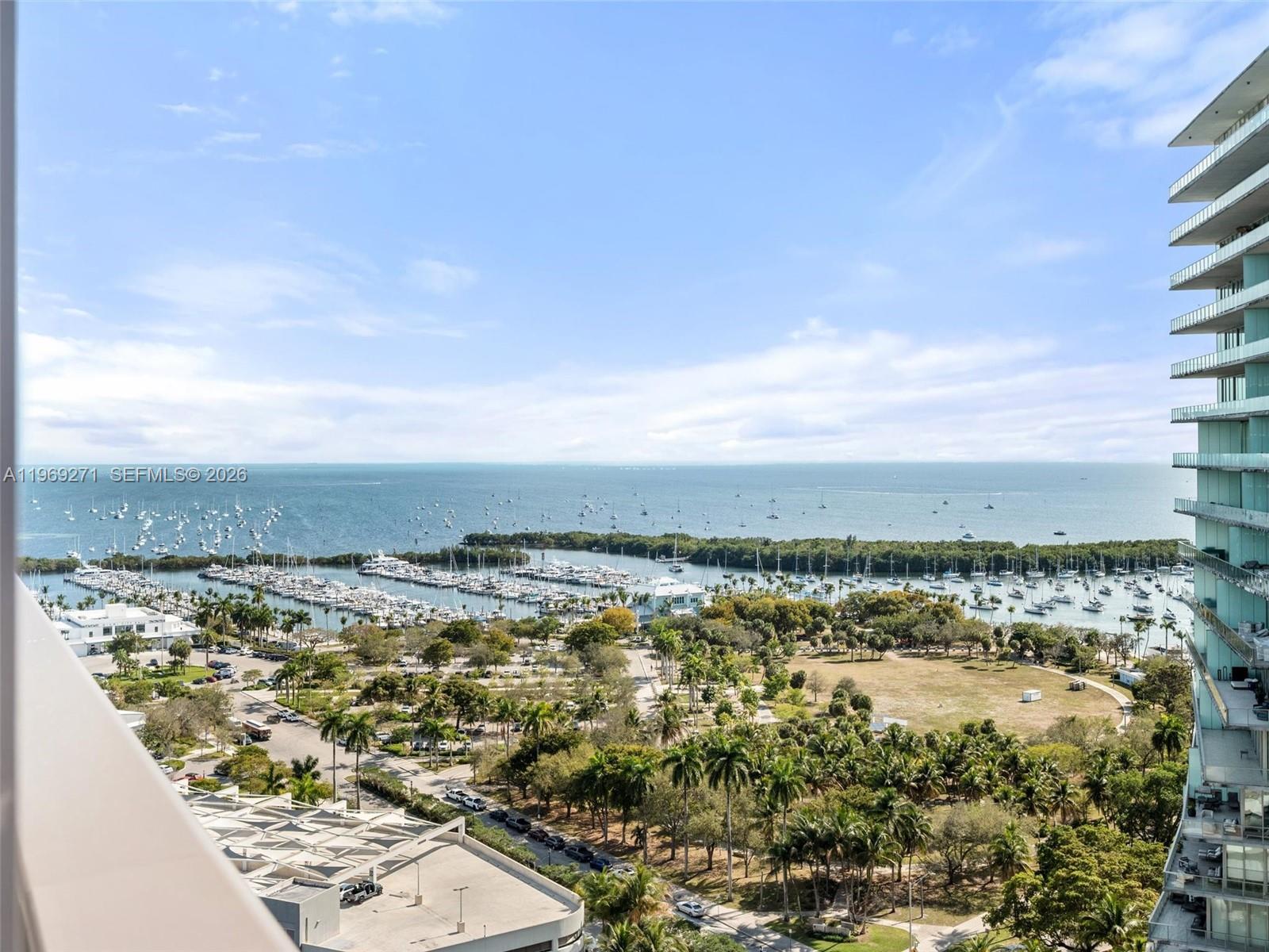 An elevated view shows a marina, a park, and the ocean from a balcony — 2655 S Bayshore Dr # 1707, Miami FL 33133, MIAMI, FL