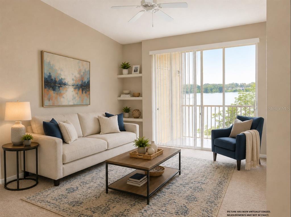 A living room with a sofa, armchair, coffee table, and sliding glass doors overlooking a lake — 1420 LAKE SHADOW CIRCLE UNIT 9306, MAITLAND, FL
