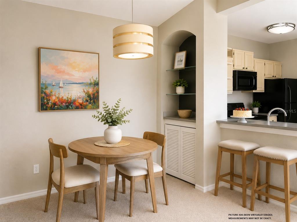 A dining area features a round wooden table, two chairs, and a built-in arched shelving unit — 1420 LAKE SHADOW CIRCLE UNIT 9306, MAITLAND, FL