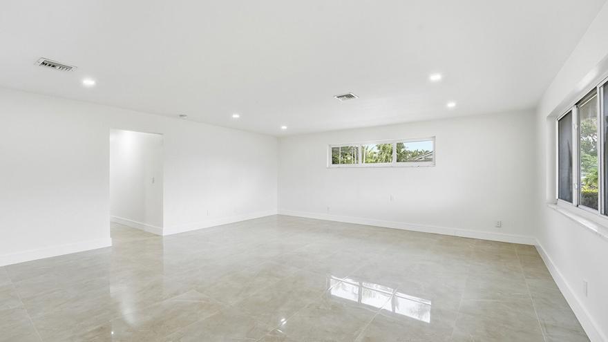 An empty room with white walls, recessed lighting, and large light-colored tile flooring — 21020 Highland Lakes Boulevard, Miami FL 33179, MIAMI, FL