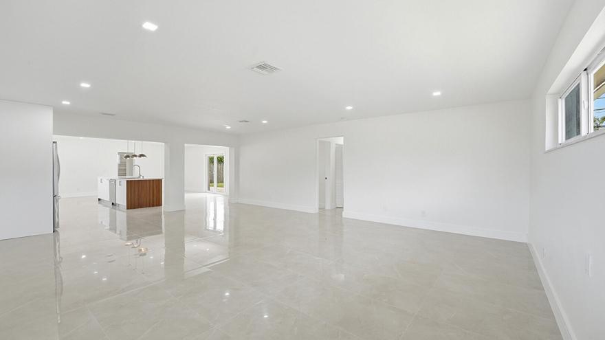 A bright, open-concept living area features white walls, recessed lighting, and large light-colored floor tiles — 21020 Highland Lakes Boulevard, Miami FL 33179, MIAMI, FL