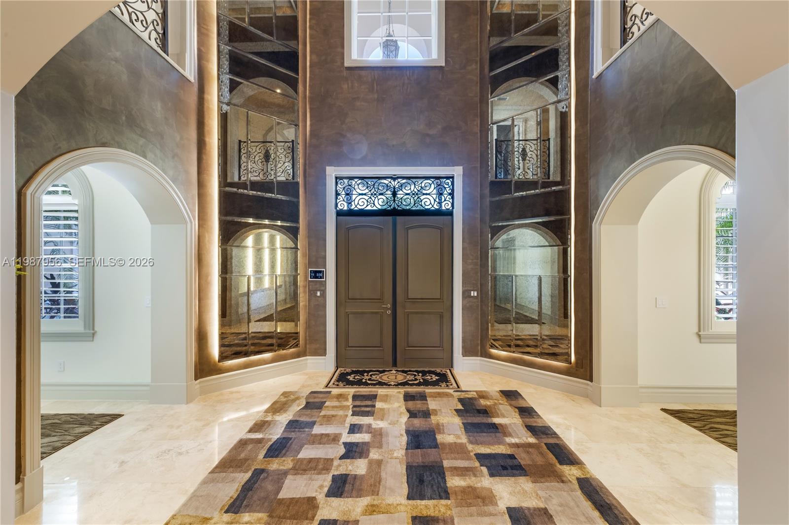 A grand foyer features a double door entrance, mirrored walls, arched doorways, and tile flooring — 5250 Snapper Creek Rd, Coral Gables FL 33156, CORAL GABLES, FL