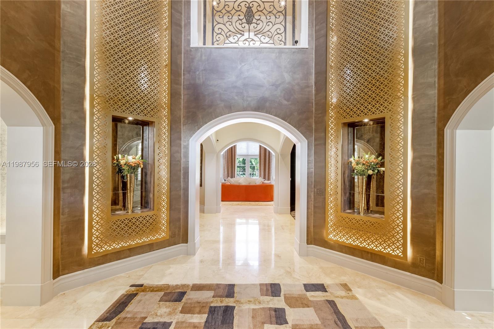 A grand foyer features arched doorways, gold lattice wall panels, and polished stone flooring — 5250 Snapper Creek Rd, Coral Gables FL 33156, CORAL GABLES, FL
