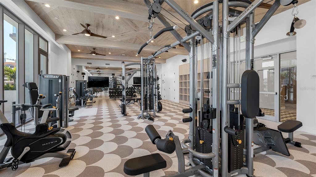 A modern gym features Matrix exercise equipment, a patterned floor, and a wood-paneled ceiling — 225 1ST AVENUE N UNIT B2, ST PETERSBURG, FL