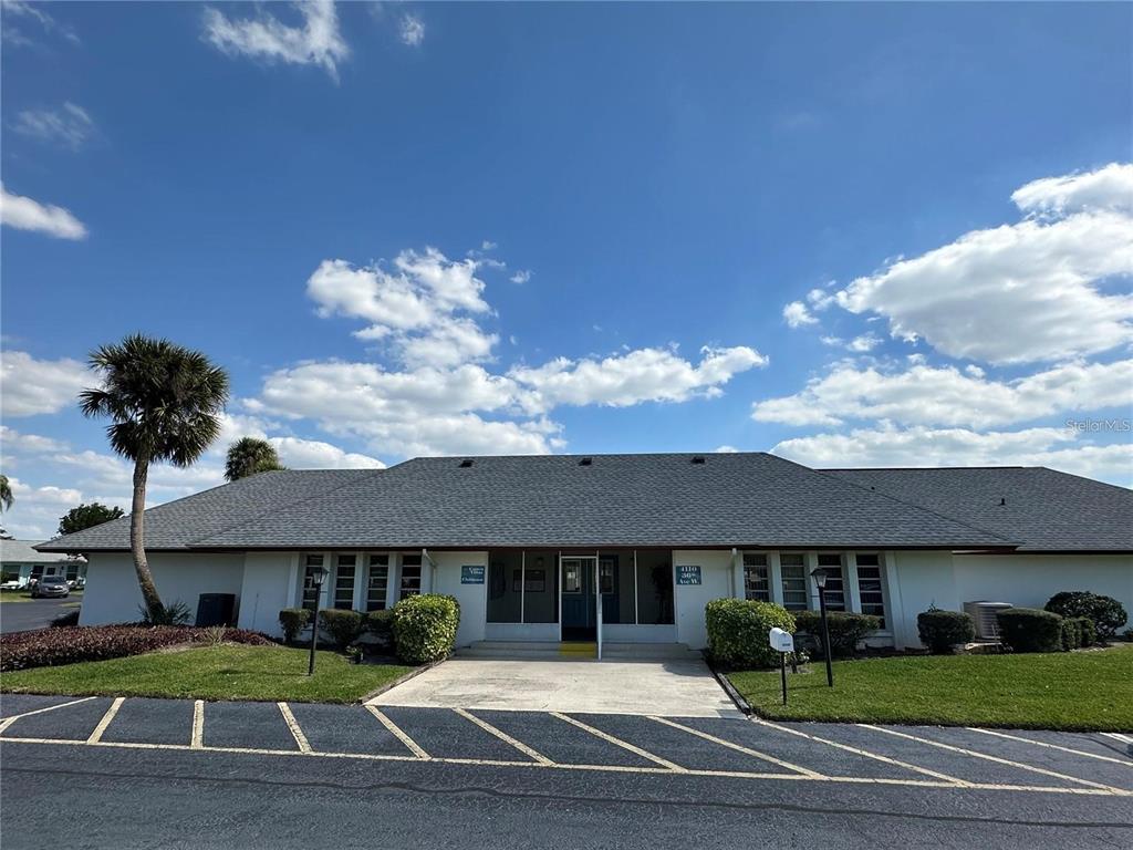 A single-story building with a gray shingled roof and a paved parking lot in front — 3401 36TH STREET W UNIT 3401, BRADENTON, FL