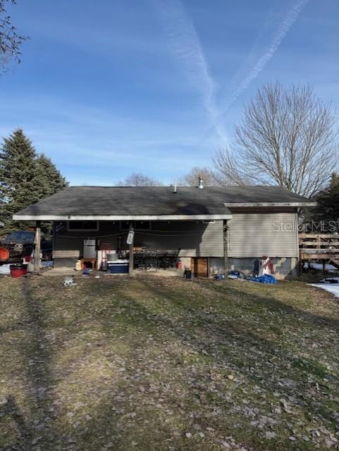 The exterior of a single-story house features gray siding, a covered patio, and a wooden deck — 5297 N HUGHES AVENUE, FOUNTAIN, MI