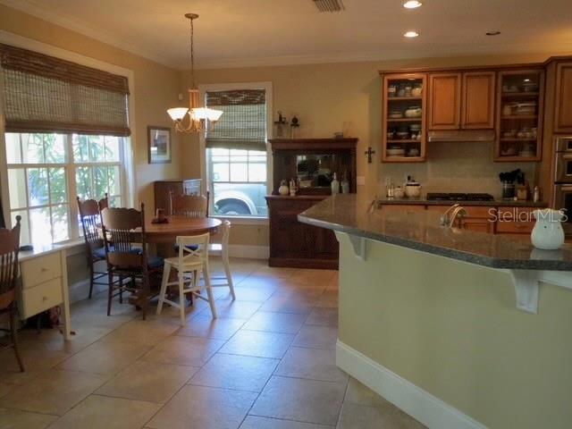 A kitchen with wooden cabinets, a breakfast nook, and a granite-topped island — 3103 W WAVERLY AVENUE, TAMPA, FL