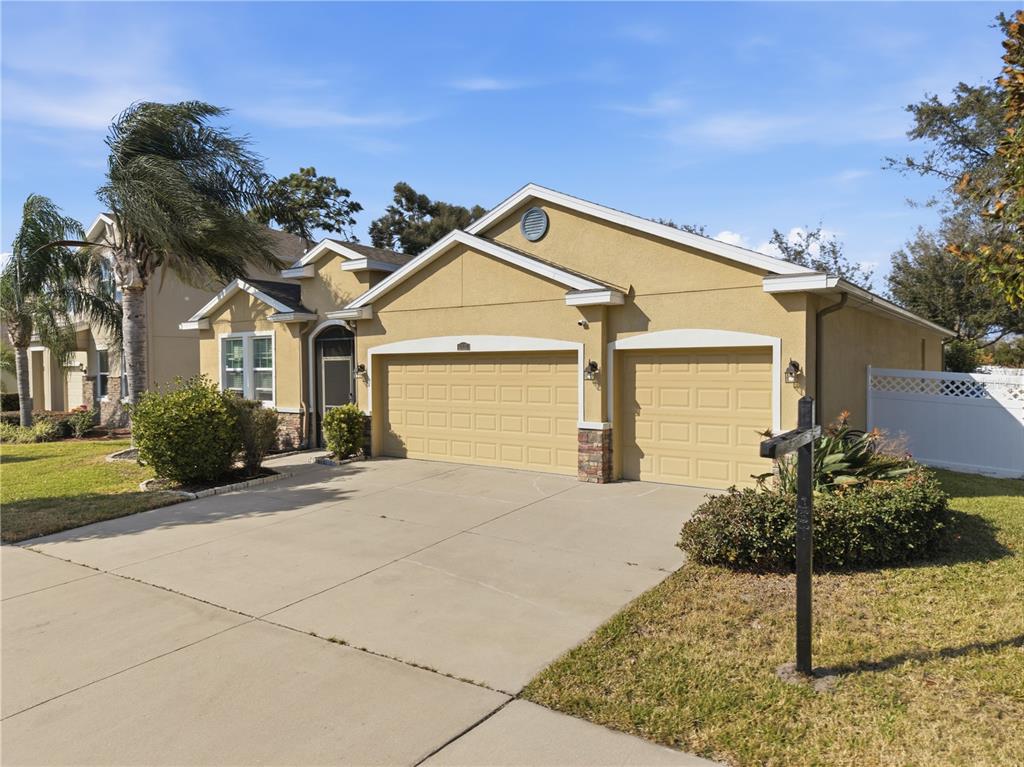 A tan, single-story house with a two-car garage and a concrete driveway — 10420 PLEASANT SPRING WAY, RIVERVIEW, FL
