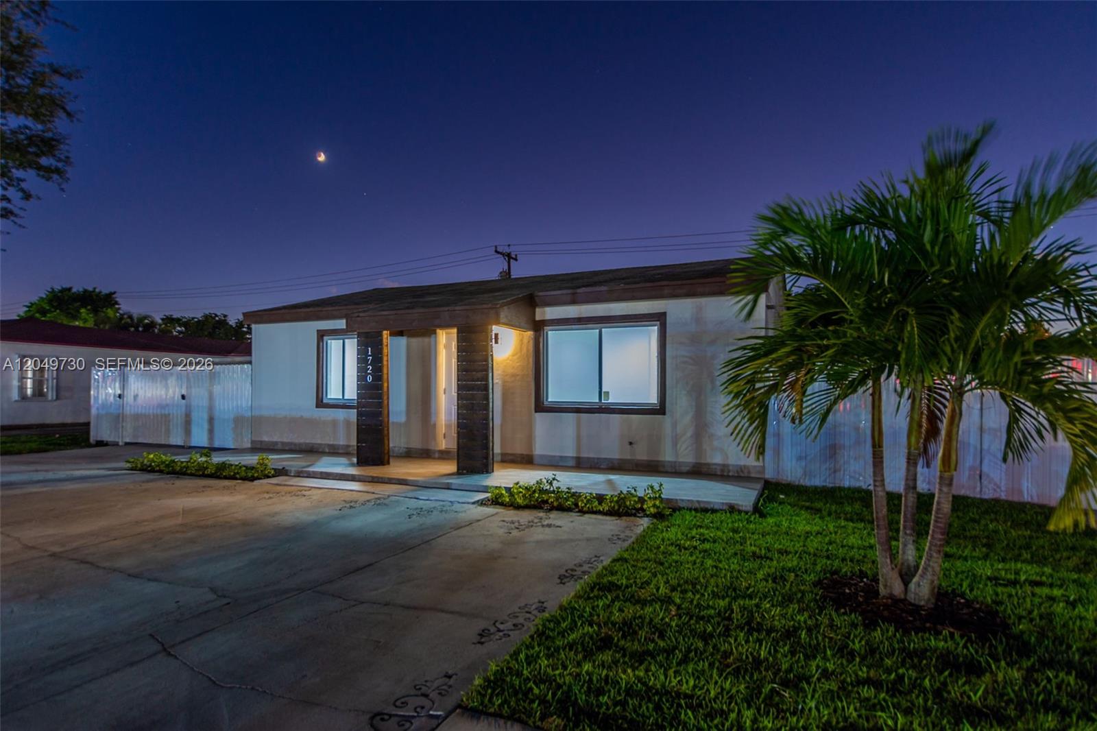 A single-story house with a concrete driveway, a palm tree, and a small front porch — 1720 NW 67th St, Miami FL 33147, MIAMI, FL