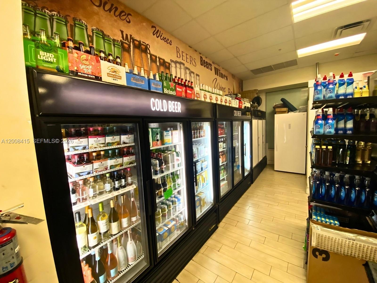 A retail store interior features rows of refrigerated beverage coolers and shelves stocked with drinks — XXXX BRICKELL AVE, Miami FL 33131, MIAMI, FL