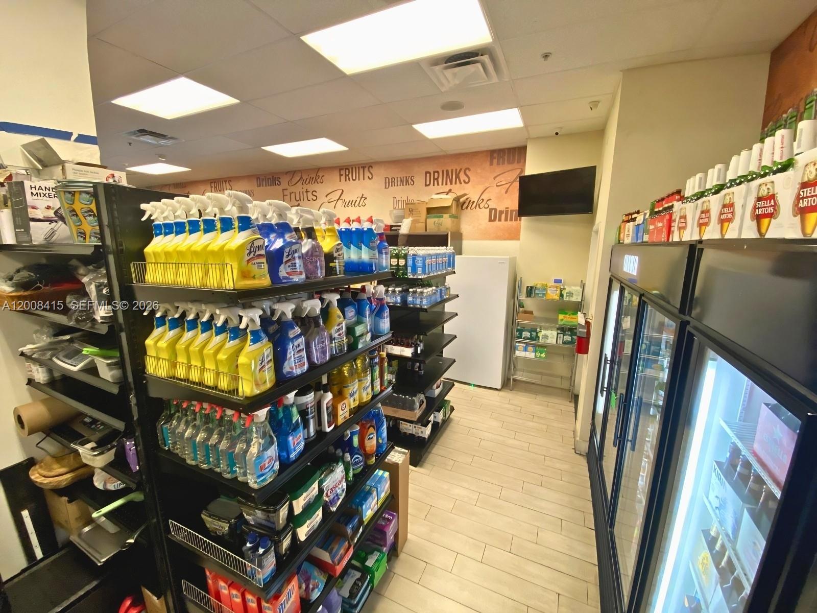 A retail store aisle features shelves stocked with cleaning supplies and refrigerated beverage displays — XXXX BRICKELL AVE, Miami FL 33131, MIAMI, FL