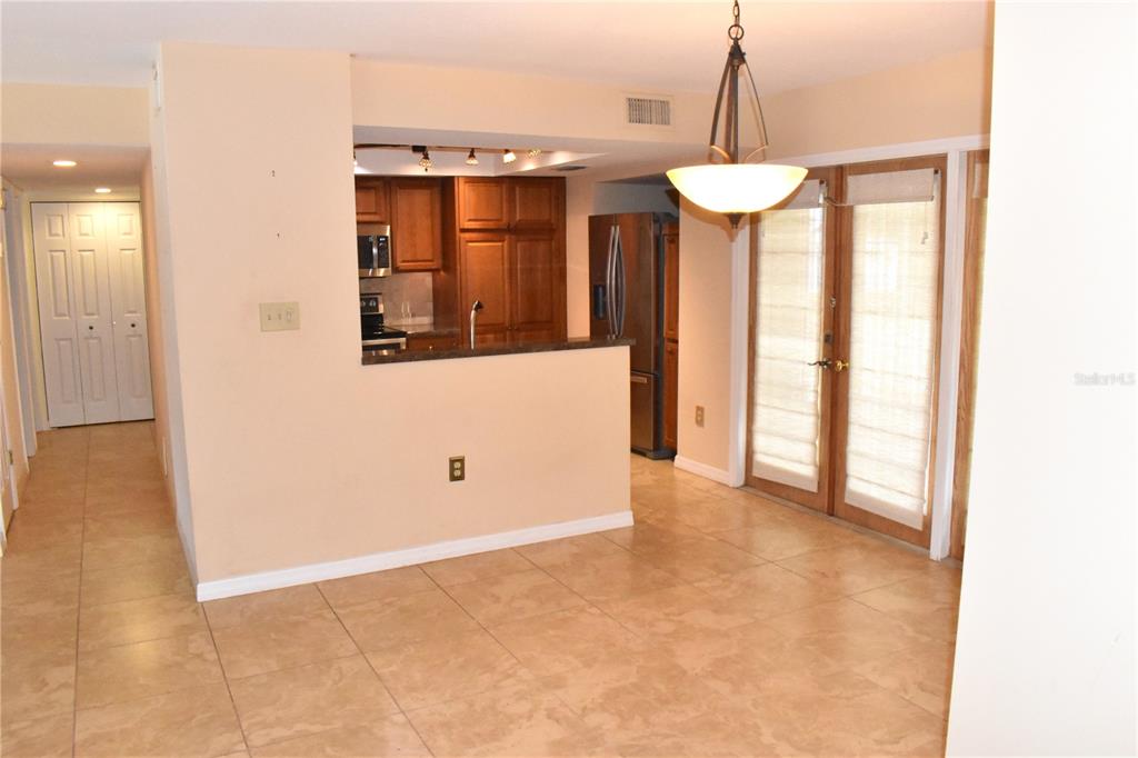 A kitchen with wood cabinets and a breakfast bar overlooks a tiled dining area — 7606 15TH AVENUE NW, BRADENTON, FL