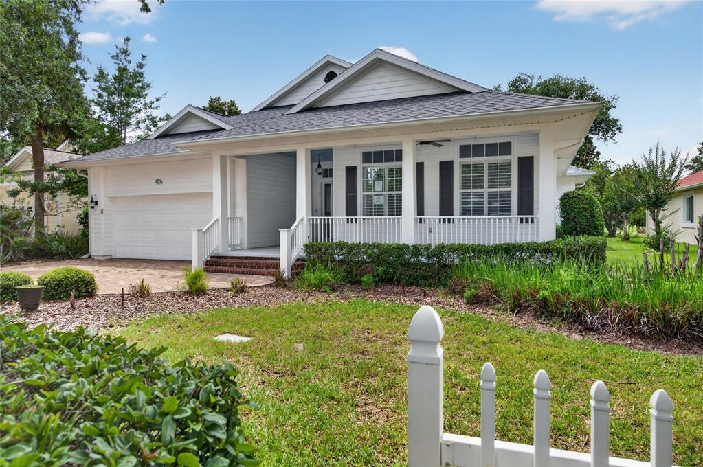 A white, single-story house with a front porch, garage, and a white picket fence — 4 CHINIER STREET, PALM COAST, FL