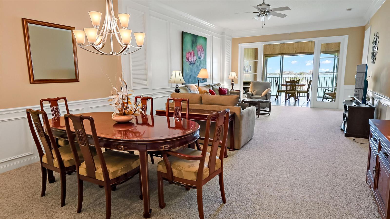 A dining area and living room with a balcony overlooking water and a ceiling fan — 4 E Harbour Isle Drive E, Fort Pierce FL 34949, FORT PIERCE, FL