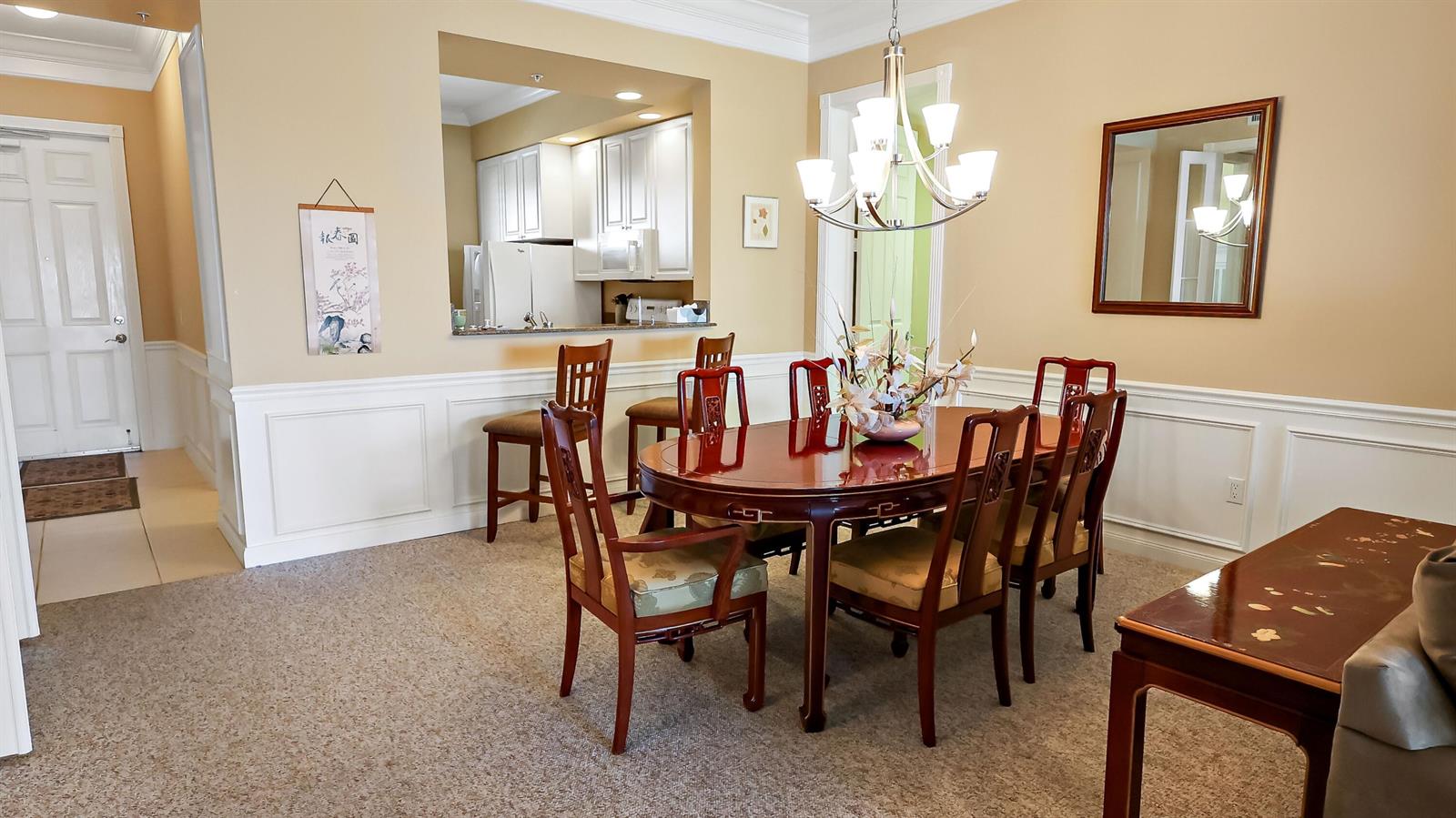 A dining room features a dark wood table with six chairs and a breakfast bar — 4 E Harbour Isle Drive E, Fort Pierce FL 34949, FORT PIERCE, FL