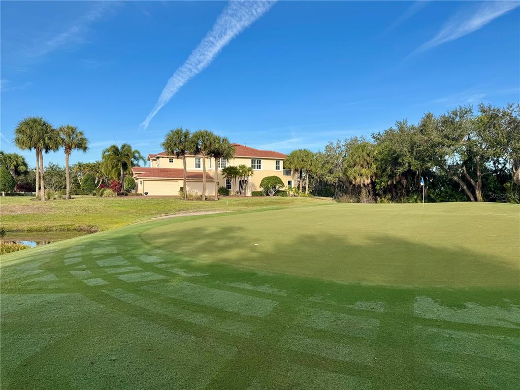 A large two-story house sits behind a manicured golf course putting green — 9411 DISCOVERY TERRACE UNIT 102B, BRADENTON, FL