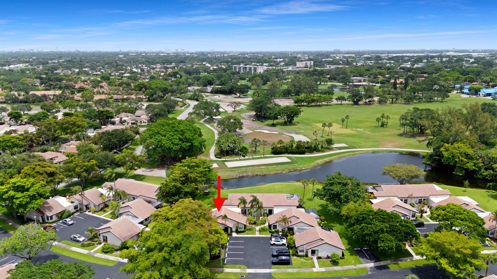 An aerial view shows a residential complex with tile roofs situated near a golf course — 3018 Lakeshore Drive, Deerfield Beach FL 33442, DEERFIELD BEACH, FL