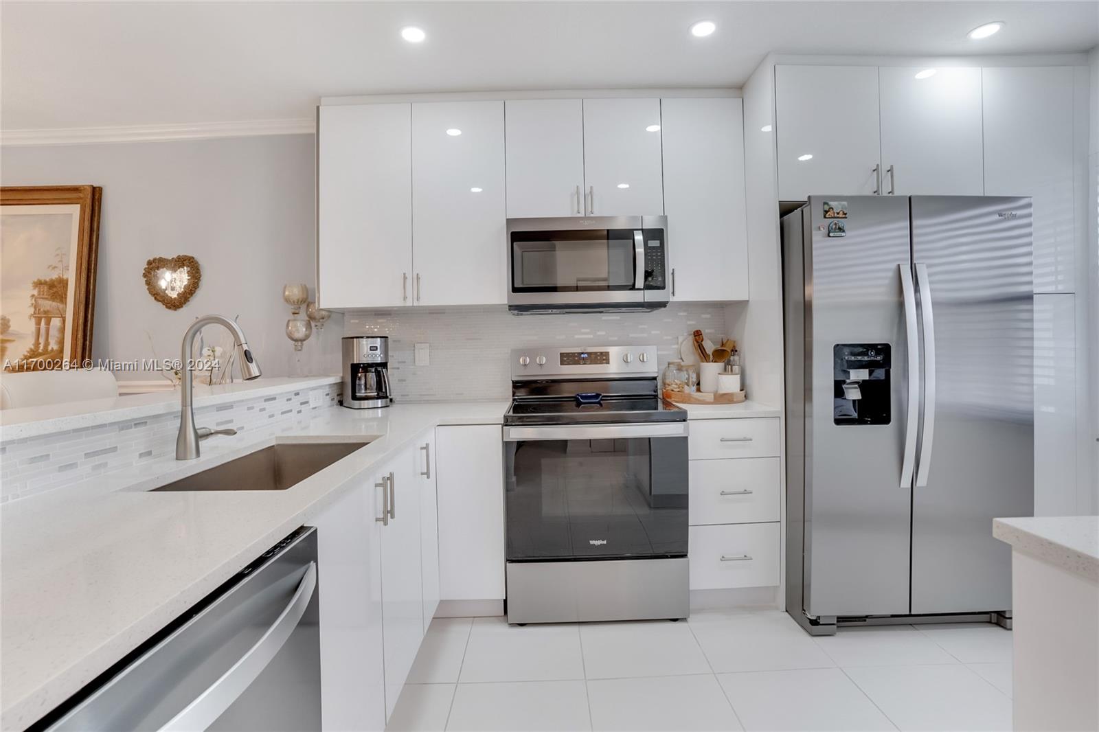 A modern kitchen features white cabinets, stainless steel appliances, and a white quartz countertop — 21364 Cypress Hammock Dr # 1H, Boca Raton FL 33428, BOCA RATON, FL