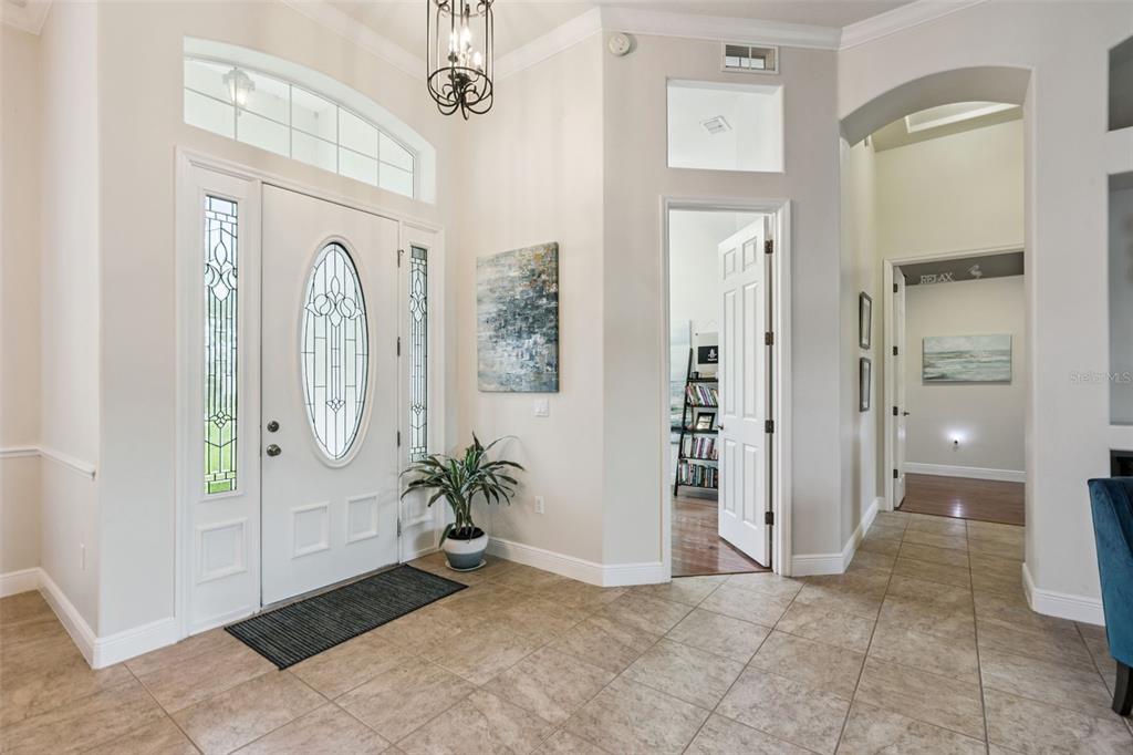 A bright entryway features tile flooring, a white front door with glass inserts, and arched doorways — 135 HICKORY STICK COURT, DEBARY, FL