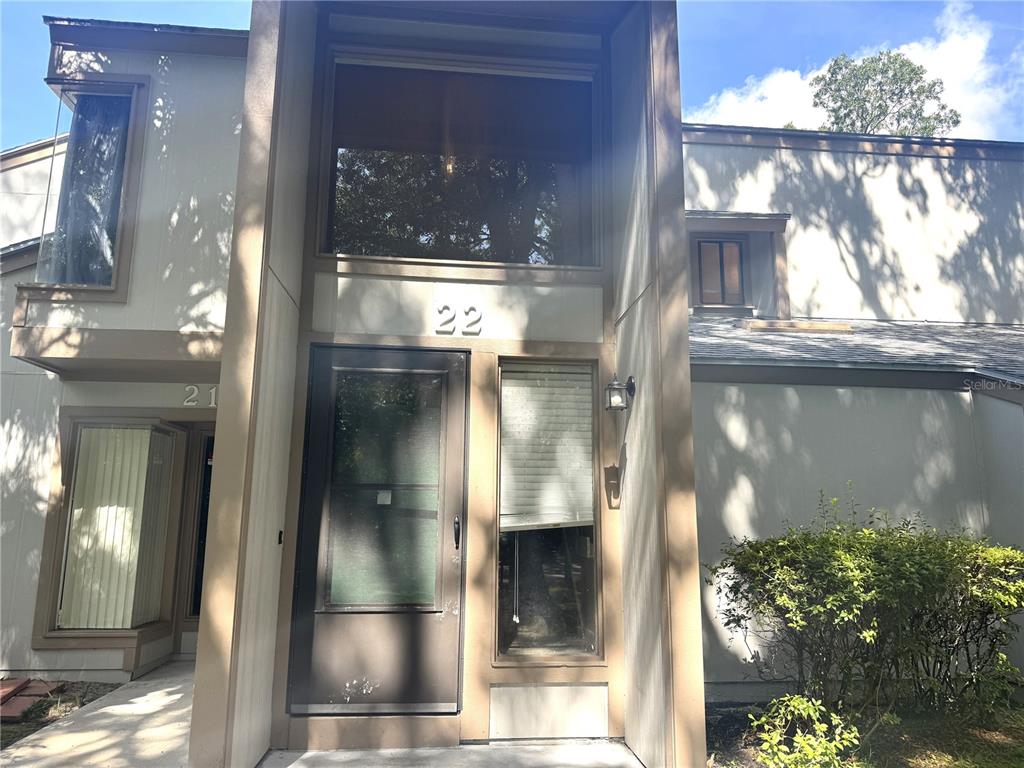 The exterior of a two-story townhouse features a front door labeled with the number 22 — 22 MID OAKS CIRCLE UNIT 22, PALM COAST, FL