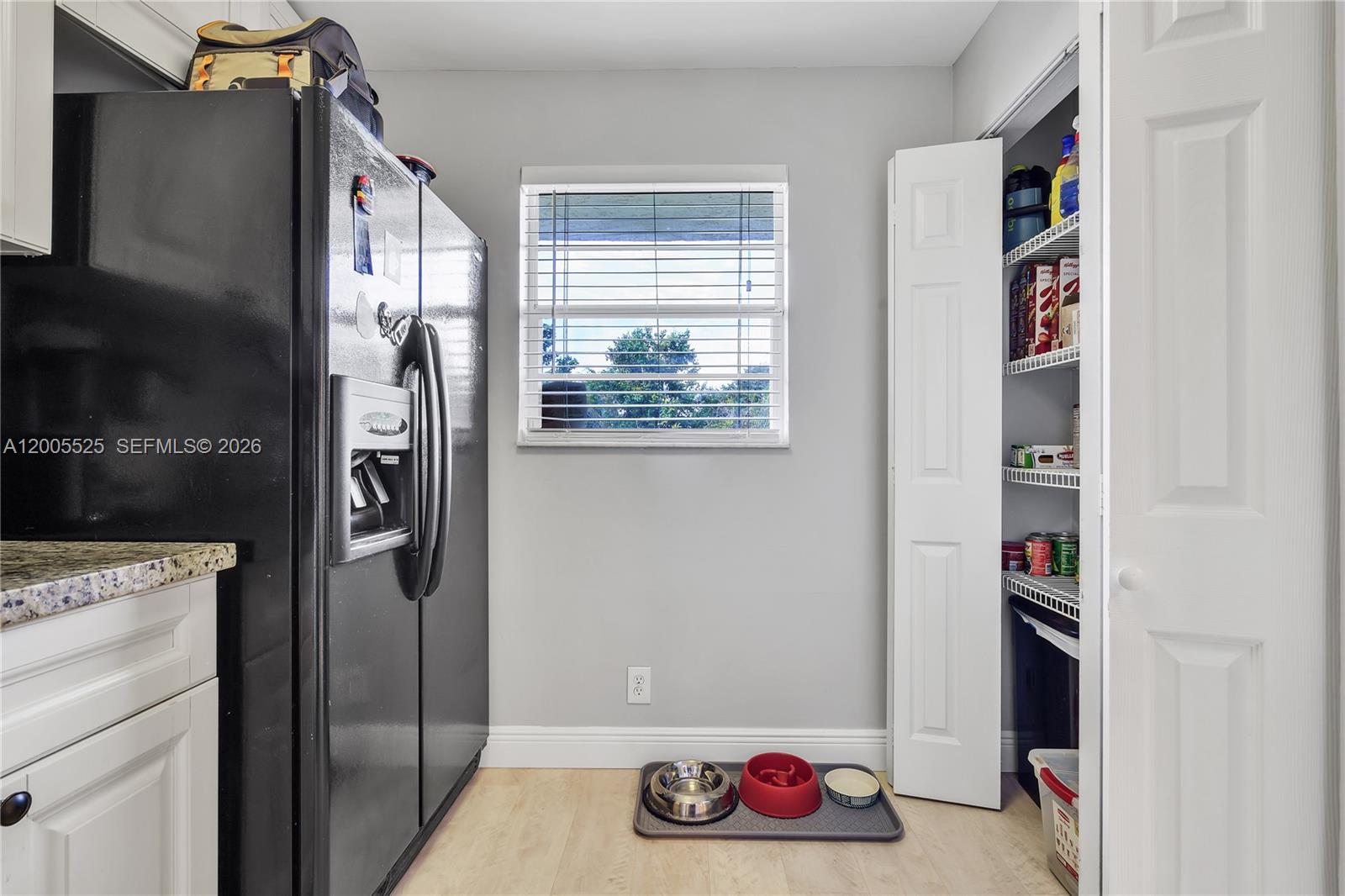 A kitchen area features a black refrigerator, a window, and an open pantry closet — 3777 NW 78th Ave # 15A, Davie FL 33024, DAVIE, FL
