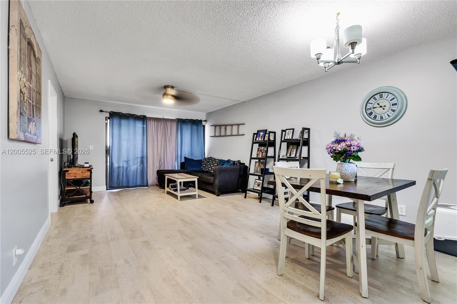 A living and dining area features light wood flooring, a dark sofa, and a dining set — 3777 NW 78th Ave # 15A, Davie FL 33024, DAVIE, FL