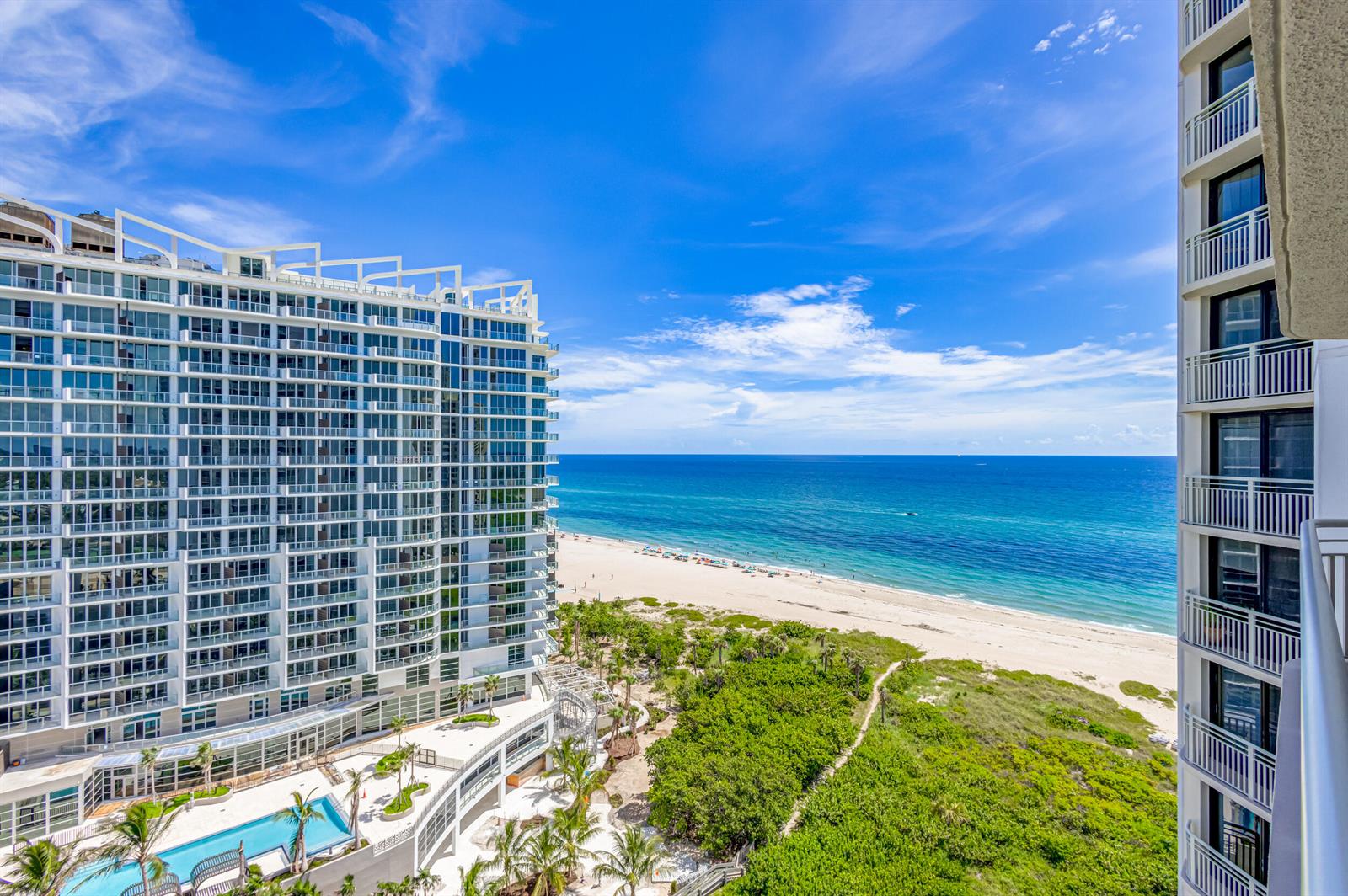 An elevated view of a beach, ocean, and two large residential buildings with swimming pools — 3000 N Ocean Drive # B, Singer Island FL 33404, SINGER ISLAND, FL
