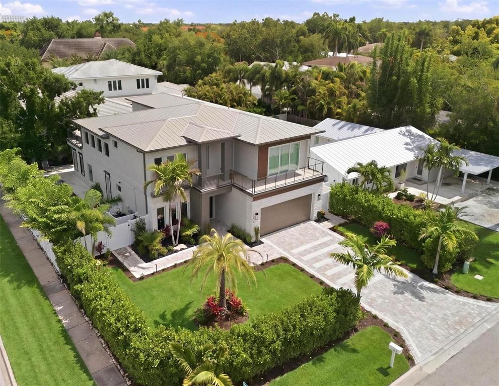 An aerial view of a modern two-story house with a metal roof and paved driveway — 1805 GOLDENROD STREET, SARASOTA, FL