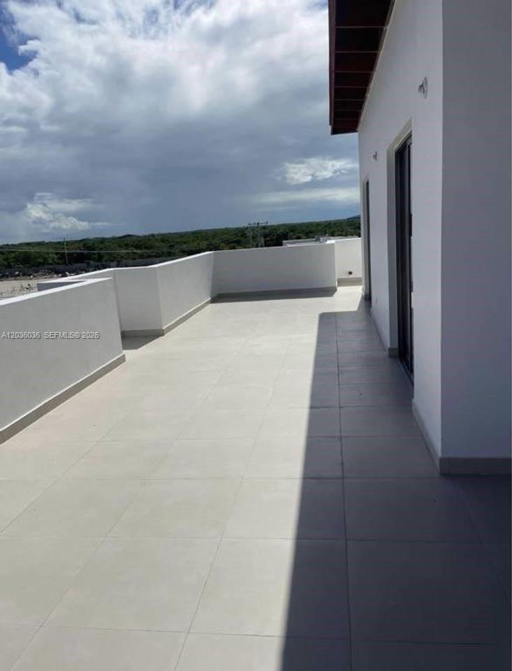 A spacious, tiled outdoor balcony features white walls and a partial roof overhang — 0 Cap cana # 0, FL