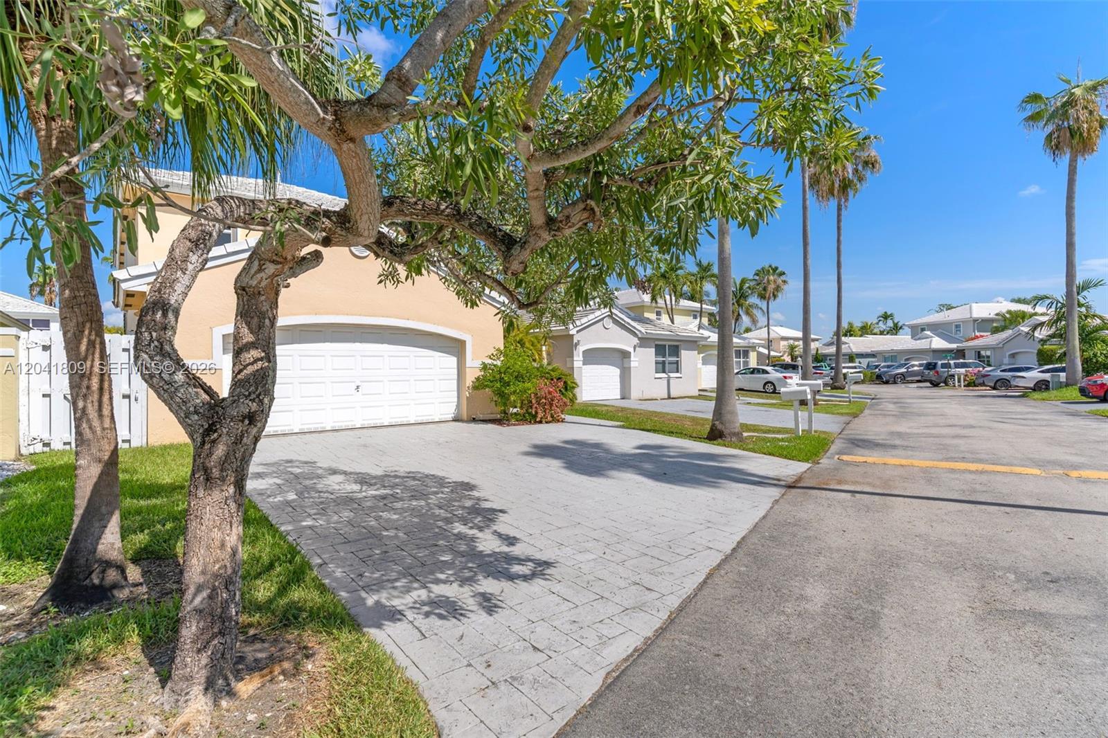 A paved driveway leads to the garage of a single-story house with palm trees — 4766 SW 154th Ave, Miami FL 33185, MIAMI, FL