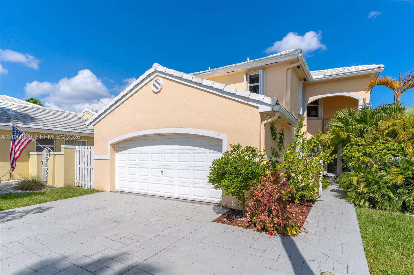 A two-story house with a beige stucco exterior, a white garage door, and a paved driveway — 4766 SW 154th Ave, Miami FL 33185, MIAMI, FL