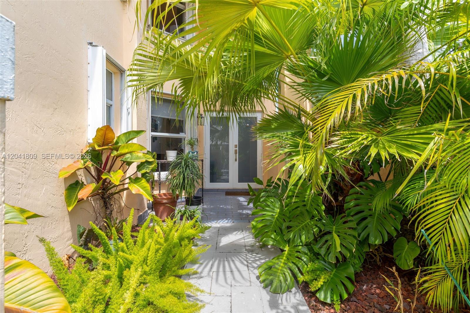 A paved walkway leads to a double-door entrance surrounded by lush tropical plants — 4766 SW 154th Ave, Miami FL 33185, MIAMI, FL