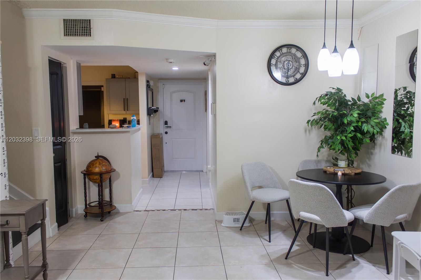 A dining area with a round table and chairs sits adjacent to a tiled entryway — 7645 NW 38th Ct, Sunrise FL 33351, SUNRISE, FL