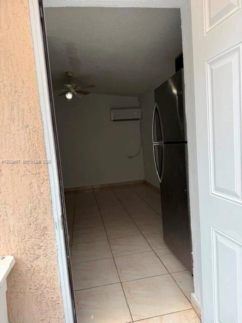 A view through a doorway shows a tiled room with a ceiling fan and refrigerator — 90 Flagami Blvd # 2, Miami FL 33144, MIAMI, FL