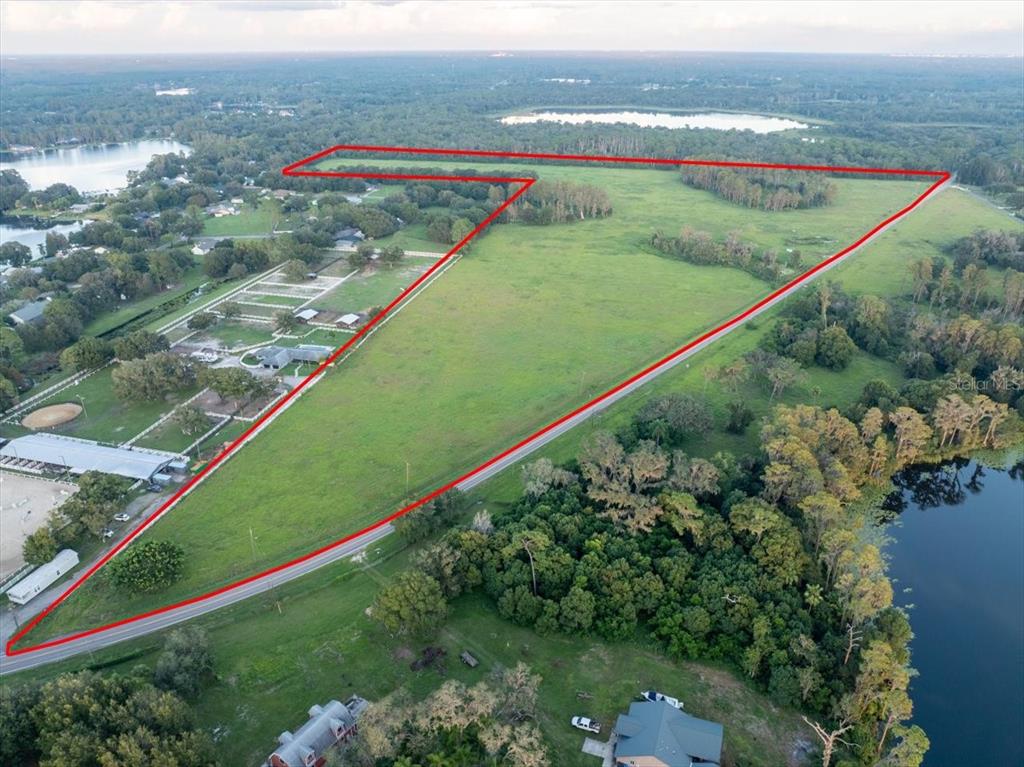 An aerial view shows a large, grassy, triangular plot of land outlined in red — 16405 BOY SCOUT ROAD, ODESSA, FL
