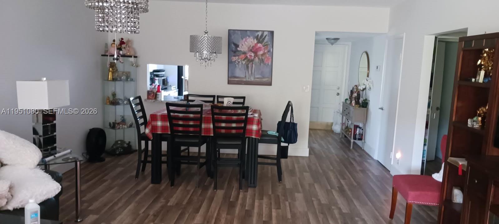 A dining area features a plaid-covered table, dark chairs, and wood-look flooring — 6731 Cypress Rd # 310, Plantation FL 33317, PLANTATION, FL
