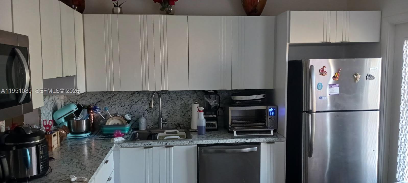 A kitchen features white cabinets, granite countertops, stainless steel appliances, and a double sink — 6731 Cypress Rd # 310, Plantation FL 33317, PLANTATION, FL