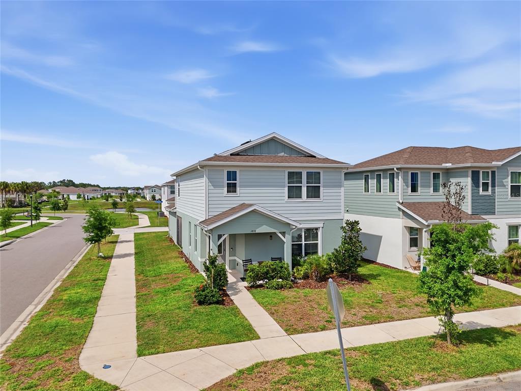 A two-story light blue house with a covered front porch and a sidewalk — 1818 GROVELINE ROAD, ST CLOUD, FL