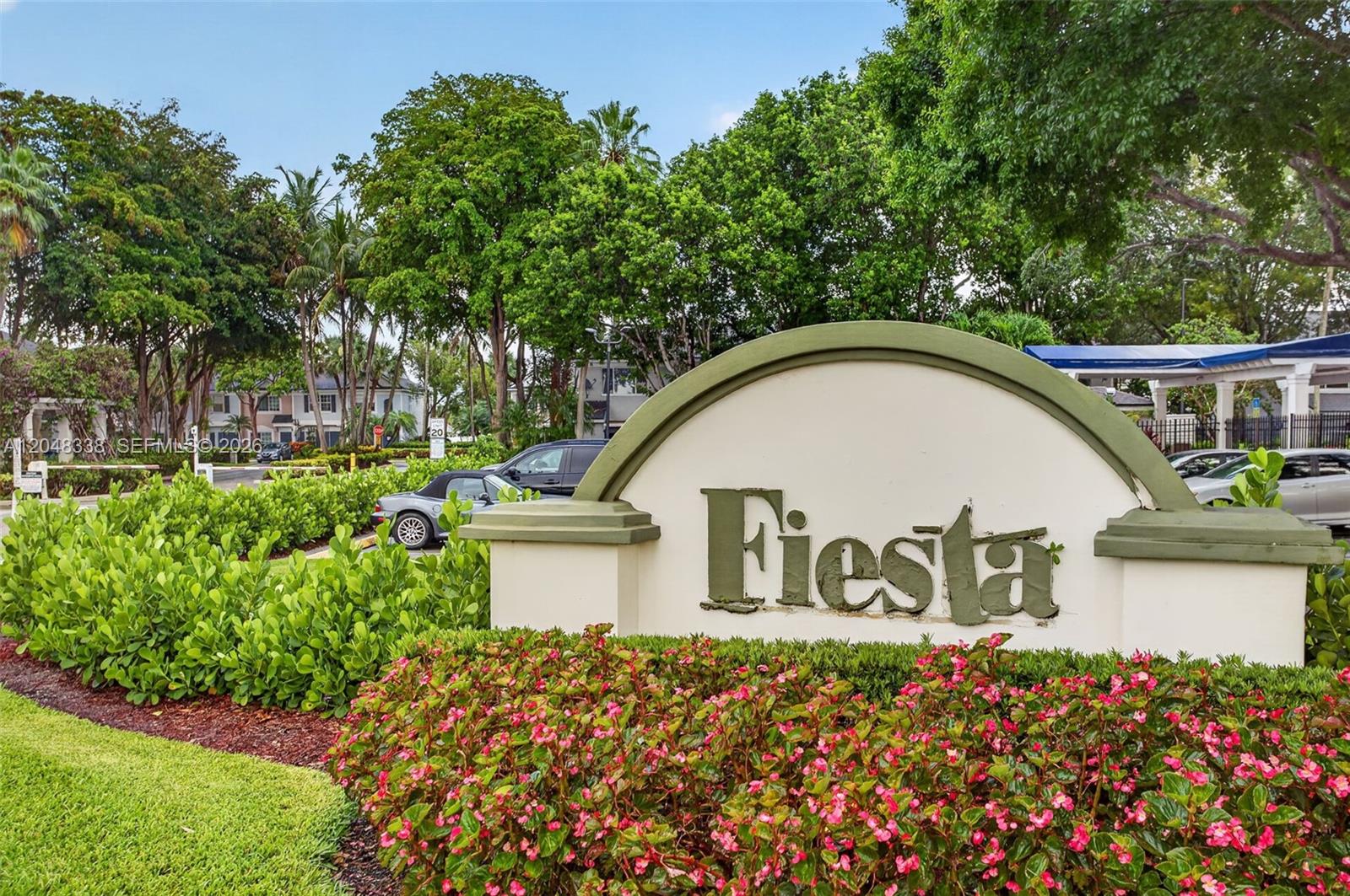 A sign reading Fiesta stands in front of a landscaped entrance with trees and cars — 3364 Celebration Ln # 156, Margate FL 33063, MARGATE, FL