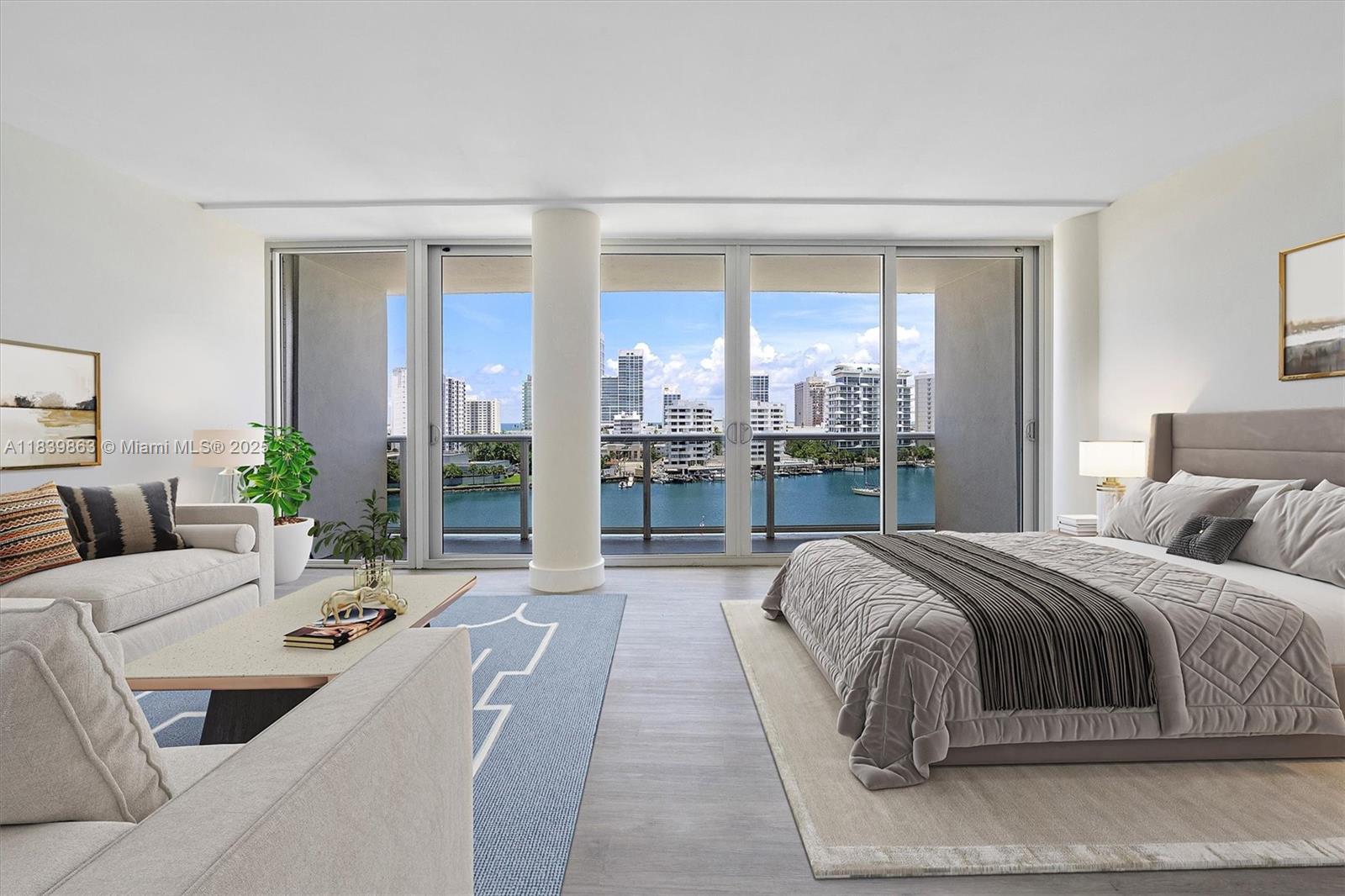 This bedroom features a seating area, a large bed, and floor-to-ceiling windows overlooking the water — 900 Bay Dr, Miami Beach FL 33141, MIAMI BEACH, FL