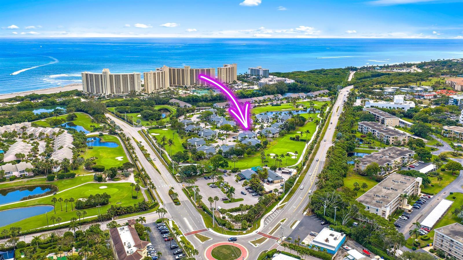 An aerial view shows a coastal resort complex with golf courses, buildings, and a roundabout — 803 Clubhouse Circle, Jupiter FL 33477, JUPITER, FL