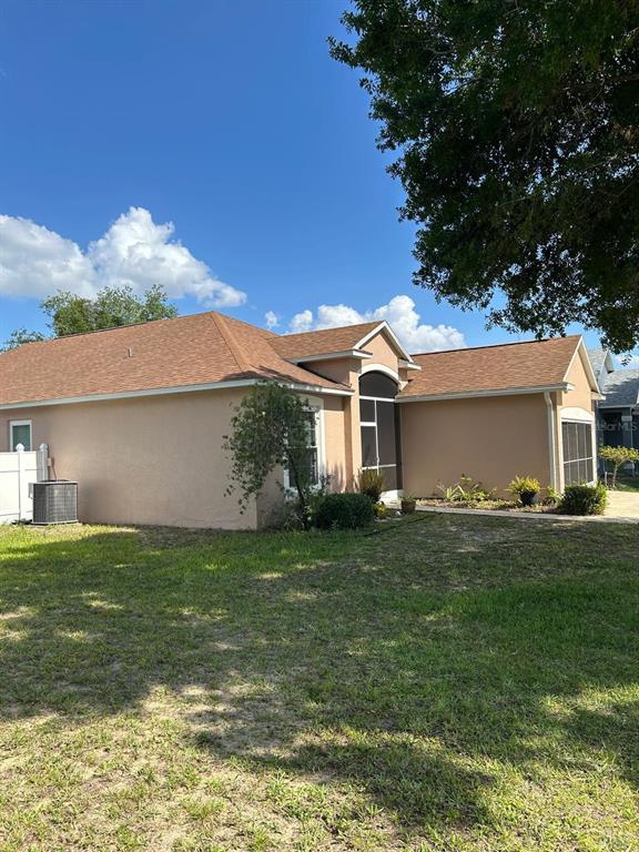 A tan, single-story house with a brown shingled roof and a screened-in porch area — 110 KNOLLWOOD DRIVE, DAVENPORT, FL